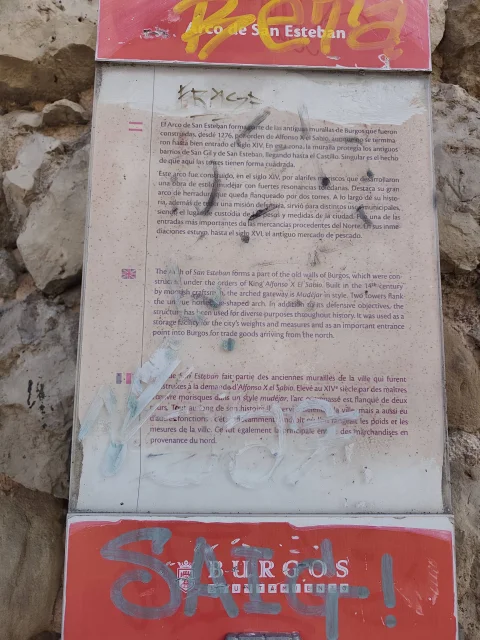 Panel informativo metálico fijado en la piedra con el texto explicativo de la historia