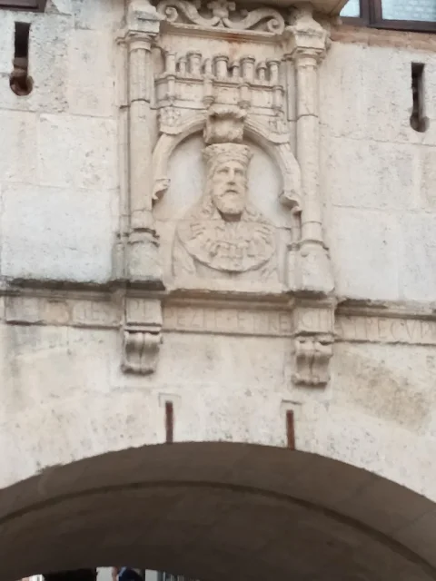 Detalle esculpido en piedra con busto real en el Arco de San Gil