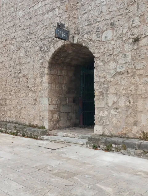 Primer plano del arco de medio punto de la Puerta de la Judería con cancela de hierro forjado