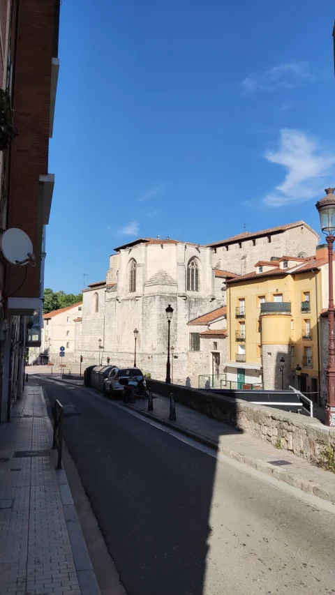 Vista de la calle pavimentada con la imponente estructura de piedra del templo alzándose en el fondo