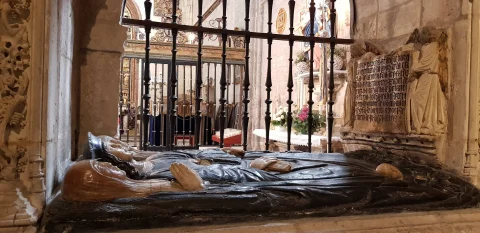 Primer plano lateral de las figuras yacentes talladas en piedra oscura