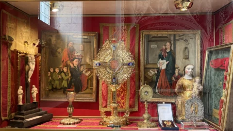 Estante superior de la vitrina con cálices, relicarios, custodia dorada y tablas pintadas de la escuela hispanoflamenca