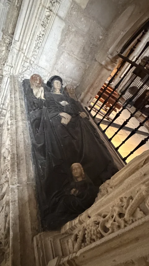 Vista en perspectiva de las figuras funerarias yacentes en piedra negra gótica dentro de su arcosolio decorado