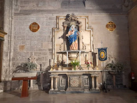 Vista detallada de la imagen de la Virgen de los Dolores presidiendo su retablo de mármol y piedra