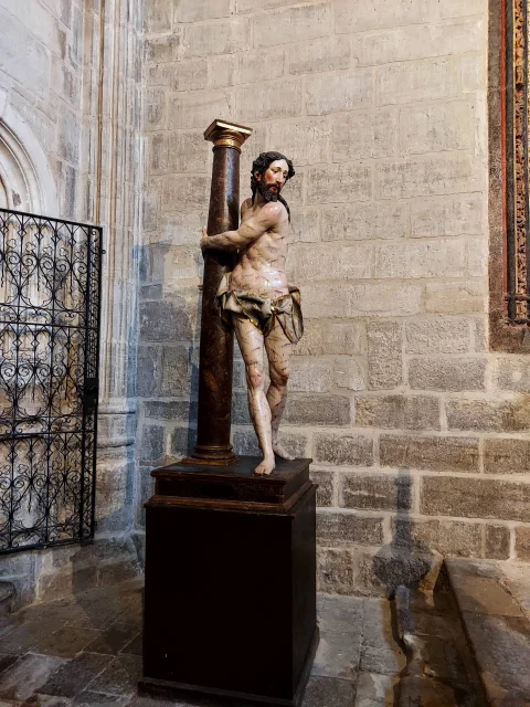 Estatua procesional de madera policromada de Cristo en la columna situada sobre un pedestal de madera