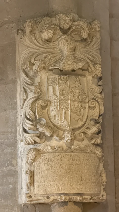 Escudo heráldico y cartela fundacional tallados en pilar
