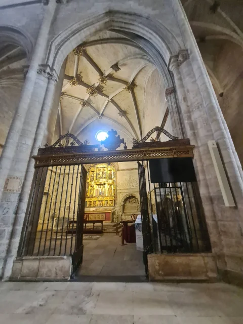Encuadre desde el exterior de la reja de hierro forjado abierta que muestra la altura de la nave