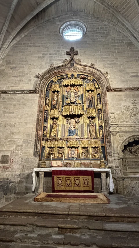 Retablo dorado de estilo gótico-renacentista con relieves religiosos y esculturas sobre altar