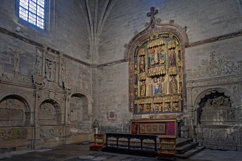 Vista angular amplia del interior de la capilla con sepulcros renacentistas, retablo mayor y altar
