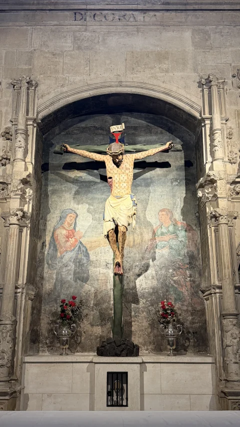 Cristo crucificado sobre el altar con pinturas murales de la Virgen María y San Juan