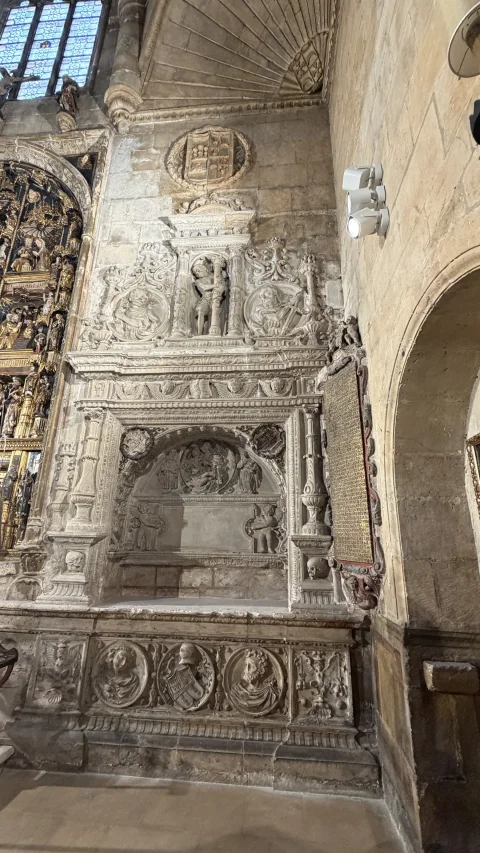 Muro lateral de la capilla con sepulcro renacentista de piedra tallada y gran cartela