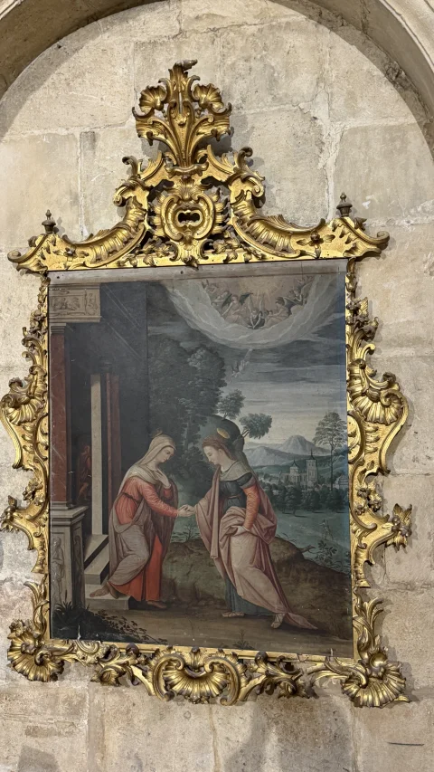 Pintura de la Visitación de la Virgen María a Santa Isabel enmarcada en una moldura dorada rococó de estilo rocalla