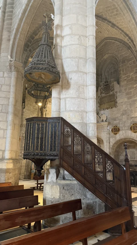 Primer plano del púlpito de hierro con calados de estilo gótico, escalera con pretil decorado y tornavoz monumental