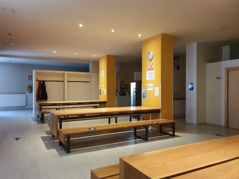 Comedor comunitario con mesas y bancos alargados