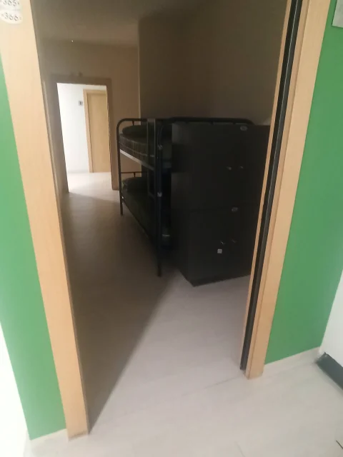 Vista desde el pasillo hacia un dormitorio de literas