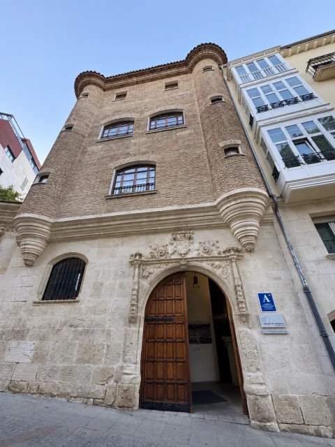 Fachada de ladrillo y piedra sillar del edificio historicista con torretas cilíndricas en las esquinas y portada renacentista