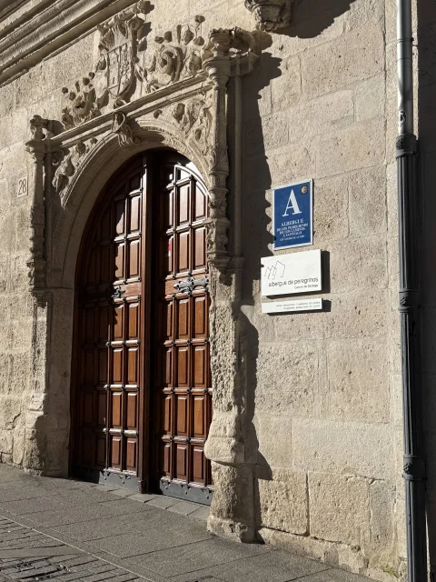Portada renacentista con el escudo y acceso al albergue