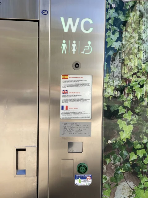 Detalle de panel de instrucciones y pictogramas de aseo público accesible