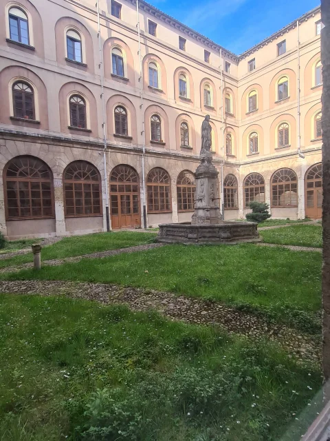 Fuente de piedra con estatua en el centro del patio claustro de la Facultad de Teología del Norte de España en Burgos