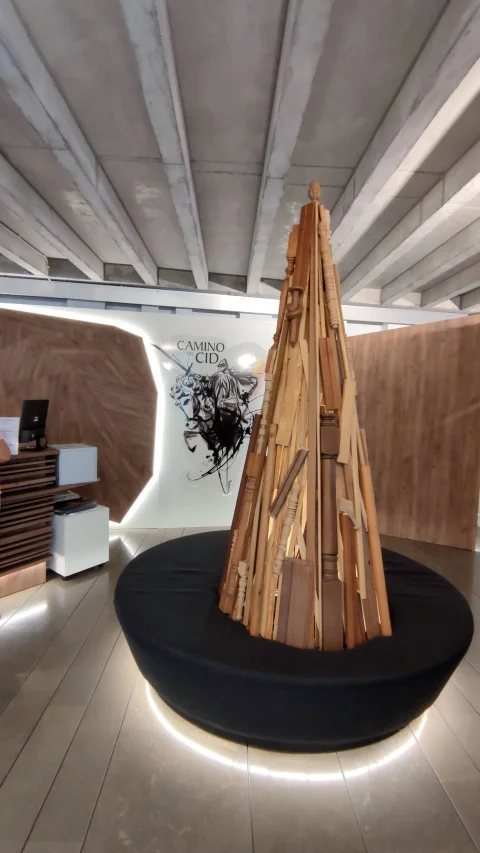 Escultura cónica de listones de madera y cartel del Camino del Cid en CITUR