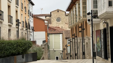 Vista hacia abajo de la empedrada Calle Hospital de los Ciegos con miradores tradicionales y la Iglesia de San Gil de fondo