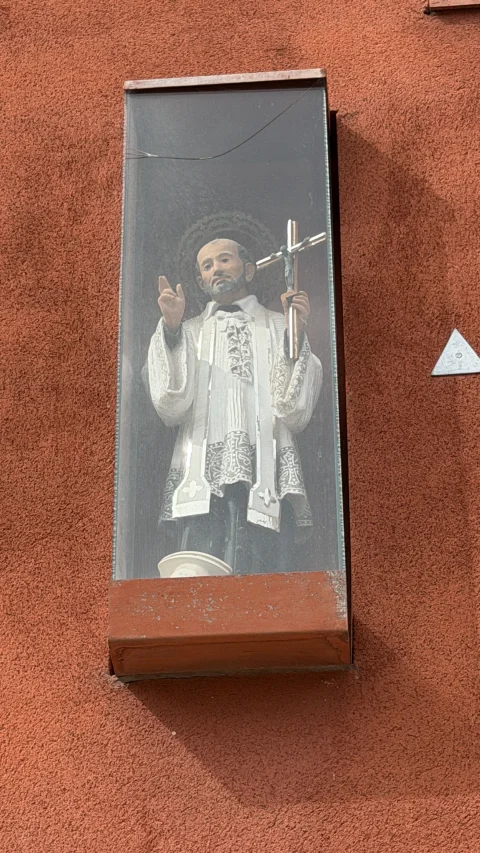 Hornacina moderna o vitrina de fachada protegida con cristal que custodia la talla de San Francisco Javier