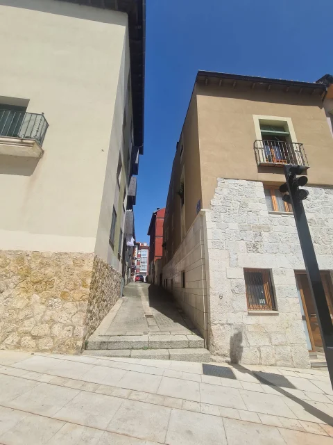 Vista frontal del inicio de la calle Saldaña entre dos edificios residenciales en Burgos