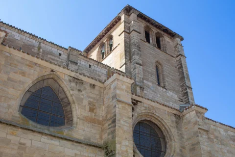 Contrapicado de la torre prismática del campanario y los grandes ventanales circulares y apuntados del templo