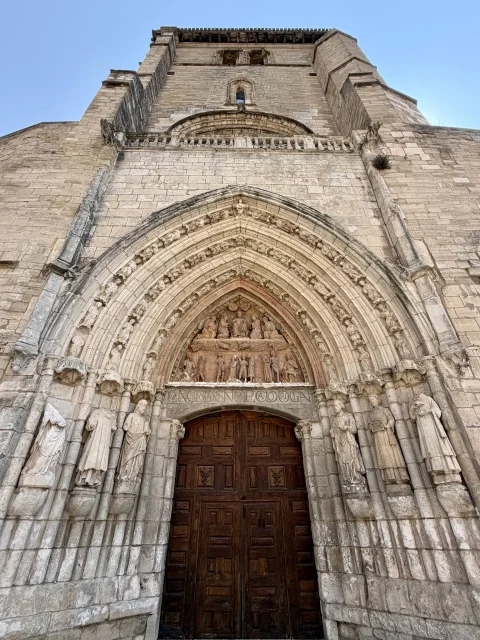 Perspectiva desde abajo hacia la portada gótica esculpida de madera y la fachada monumental de la iglesia de San Esteban