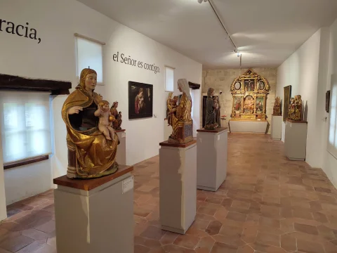 Galería de exposición con esculturas de la Virgen María expuestas sobre pedestales individuales