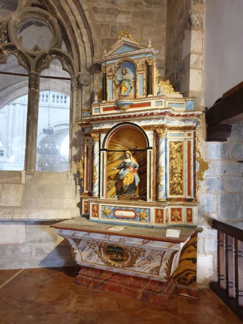 Retablo de madera pintada con efecto marmolado y una figura central de la Virgen en hornacina