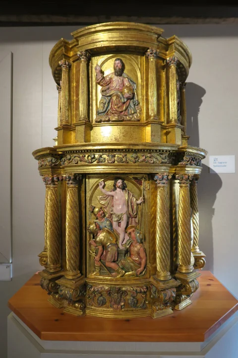 Sagrario cilíndrico de madera dorada con relieve frontal de Cristo Resucitado saliendo del sepulcro