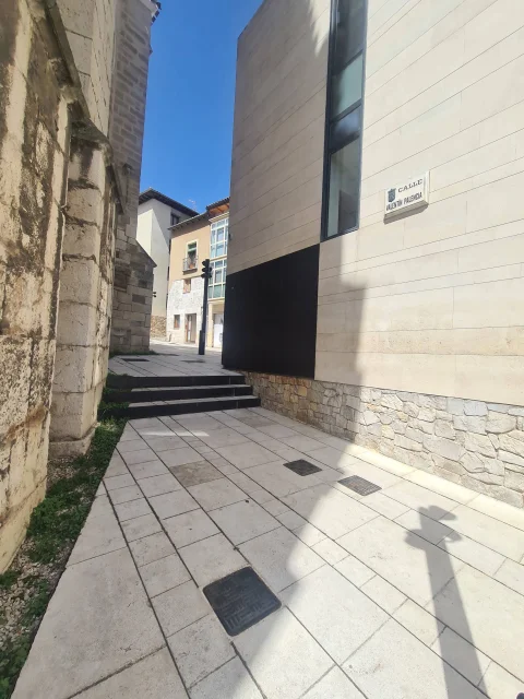 Placa con la rotulación de Calle Valentín Palencia en una fachada de piedra clara