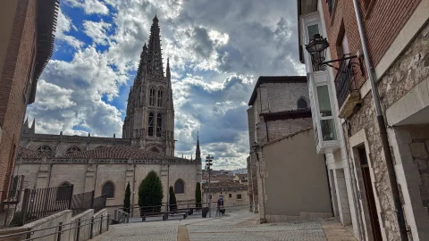 Torre gótica de la Catedral de Burgos enmarcada entre los edificios de viviendas de la Calle Pozo Seco