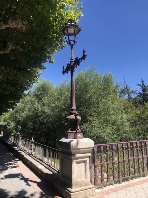 Farola clásica del Puente de Bessón rodeada de arbolada