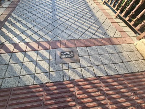 Placa identificativa del Puente Bessón en el suelo del paseo