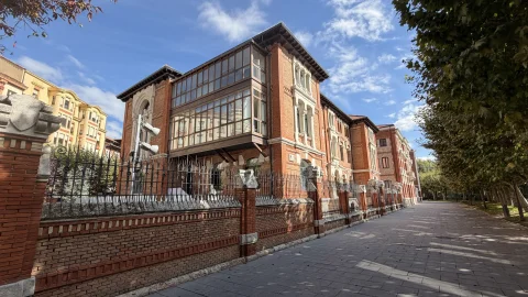 Edificio de ladrillo con mirador de madera y verja de forja en el Paseo de la Audiencia de Burgos