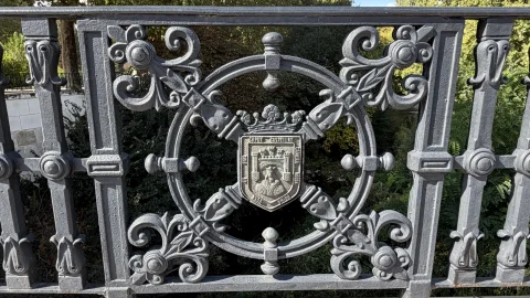Detalle de forja en hierro con el escudo de armas de la ciudad de Burgos en la barandilla del Puente de Castilla