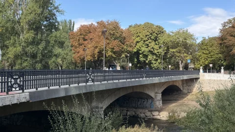 Vista lateral del Puente de Castilla con sus arcos de piedra y barandilla de hierro sobre el río Arlanzón en Burgos