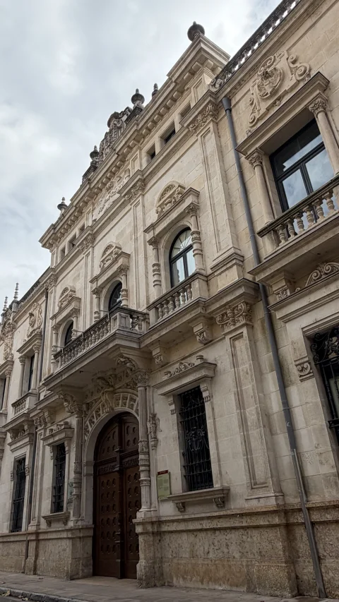 Entrada principal de madera con arcos y balcones de piedra en el Arzobispado de Burgo