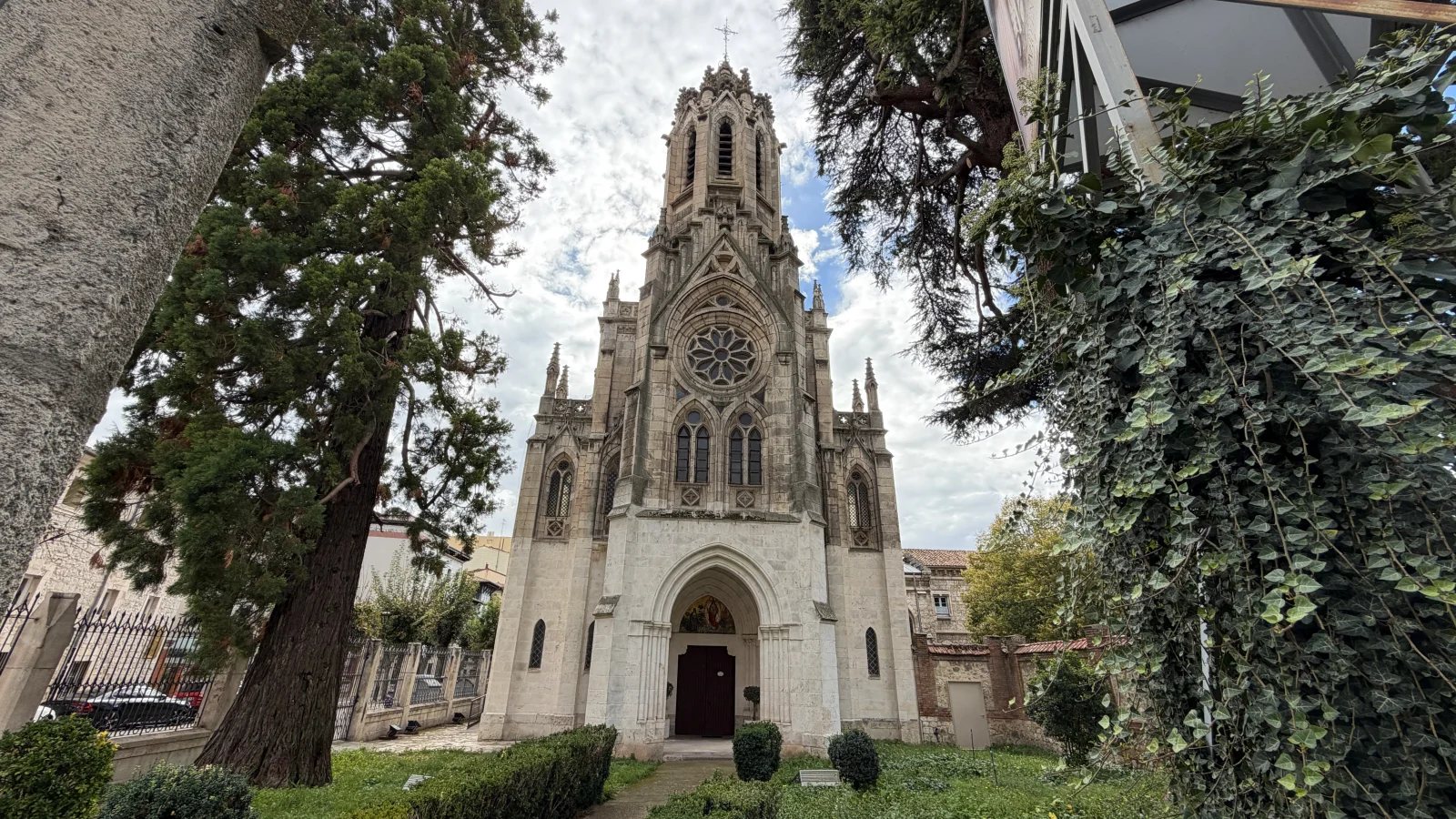 Vista en perspectiva de la Iglesia de las Salesas enmarcada por los árboles del jardín frontal
