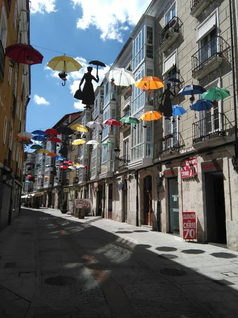 Instalación temporal de paraguas de colores sobre una calle del centro de Burgos