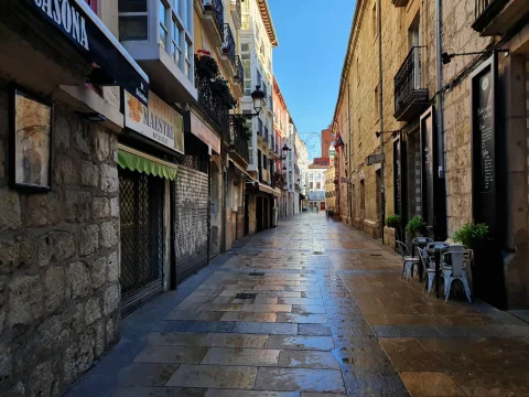 Calle San Lorenzo de Burgos a primera hora de la mañana, vacía y con el pavimento de losa mojado
