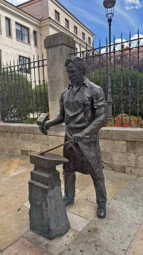 Estatua del Herrero de Burgos junto a la verja de forja de la calle San Lorenzo