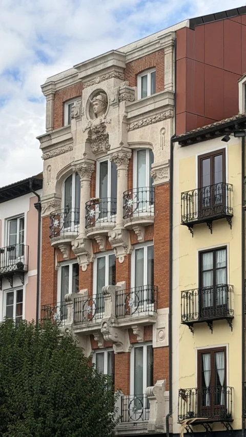 Fachada de la Casa de Mercurio de Burgos, de ladrillo rojo y piedra con balcones de forja