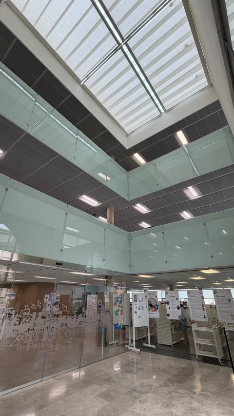 Vestíbulo de triple altura de la Biblioteca Pública de Burgos, con la luz entrando por el lucernario