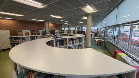 Zona infantil de la Biblioteca Pública de Burgos, con su mostrador curvo y las estanterías bajas