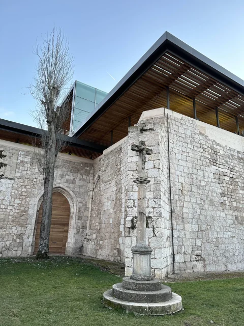 Muros de la iglesia del Monasterio de San Juan de Burgos con el crucero de piedra y la cubierta de madera asomando