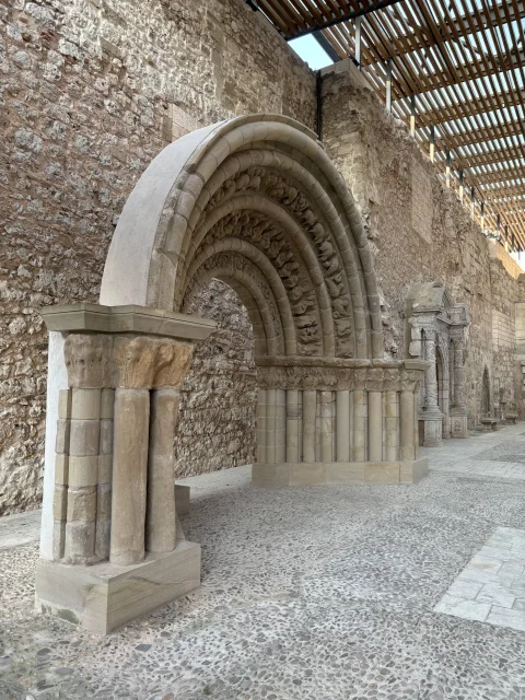 Portada románica exenta sobre zócalo nuevo en la iglesia del Monasterio de San Juan de Burgos