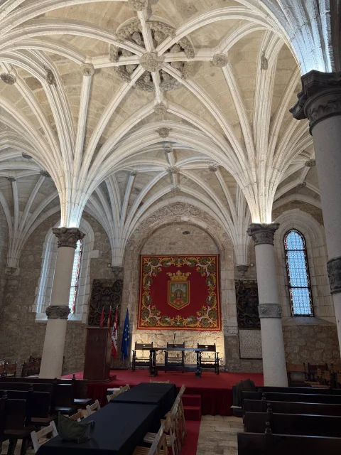 Sala capitular del Monasterio de San Juan de Burgos, con bóvedas estrelladas y el tapiz del escudo de la ciudad